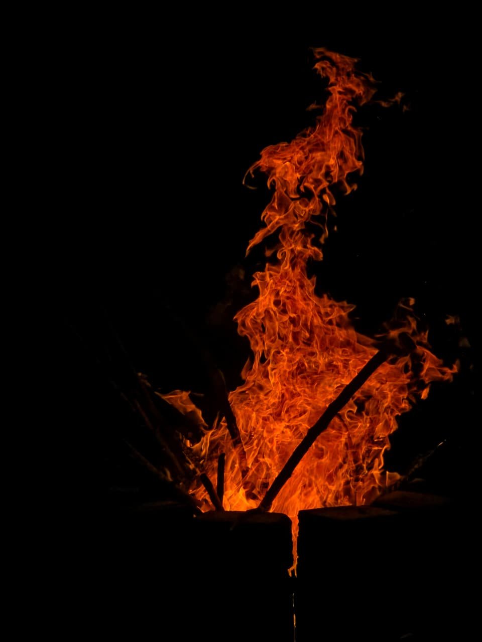 Bonfire sparks rising into the night sky